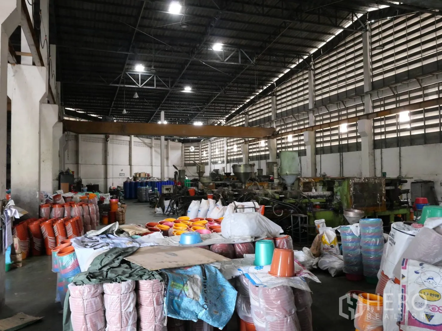 工厂 出租或出售在Bang Khun Thian, Bangkok - 车间通道摆放设备与成堆的塑料桶和袋。