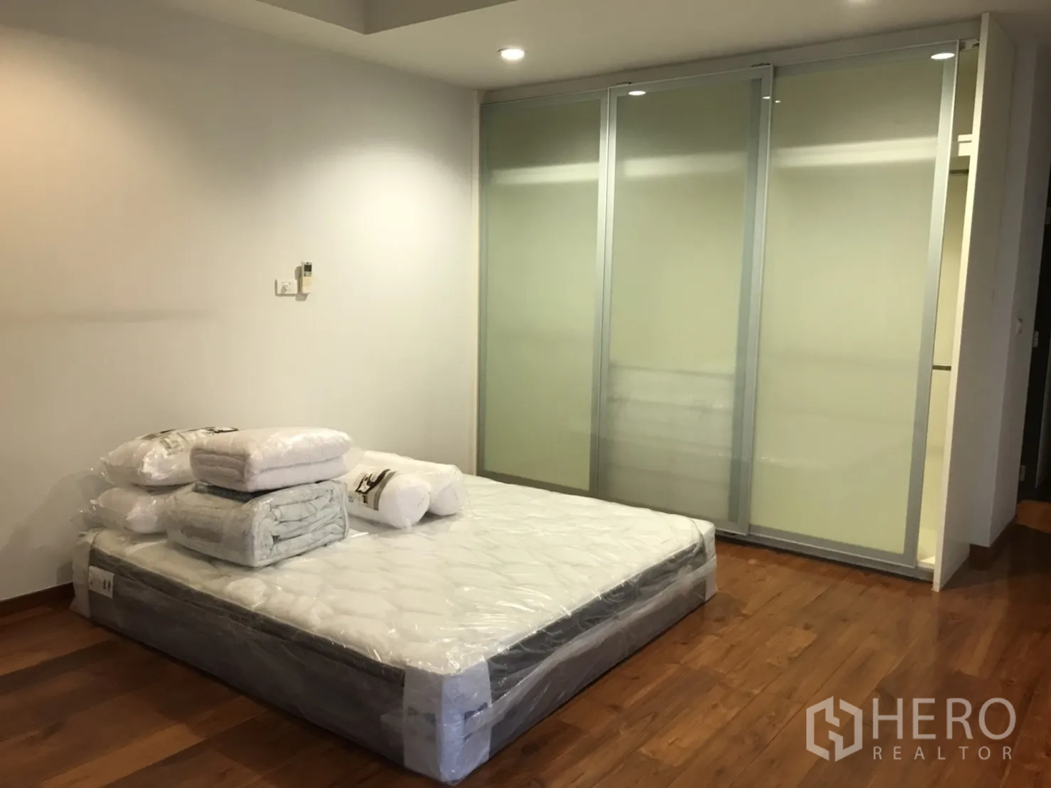 Detached House for rent in Wang Thonglang, Bangkok - Bedroom with sliding frosted-glass wardrobes and recessed ceiling lights