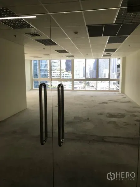 办公空间 出租在Khlong Toei, Bangkok - 透过玻璃入口门望向明亮办公室与城市景观。