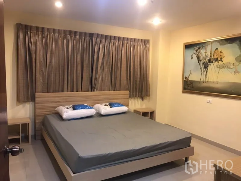 Condominium for rent in Watthana, Bangkok - Second bedroom featuring a large bed, bedside tables and wall art.