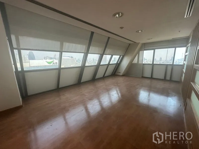 办公空间 出租在Phaya Thai, Bangkok - 带木地板的独立办公室，斜面窗户俯瞰曼谷天际线。