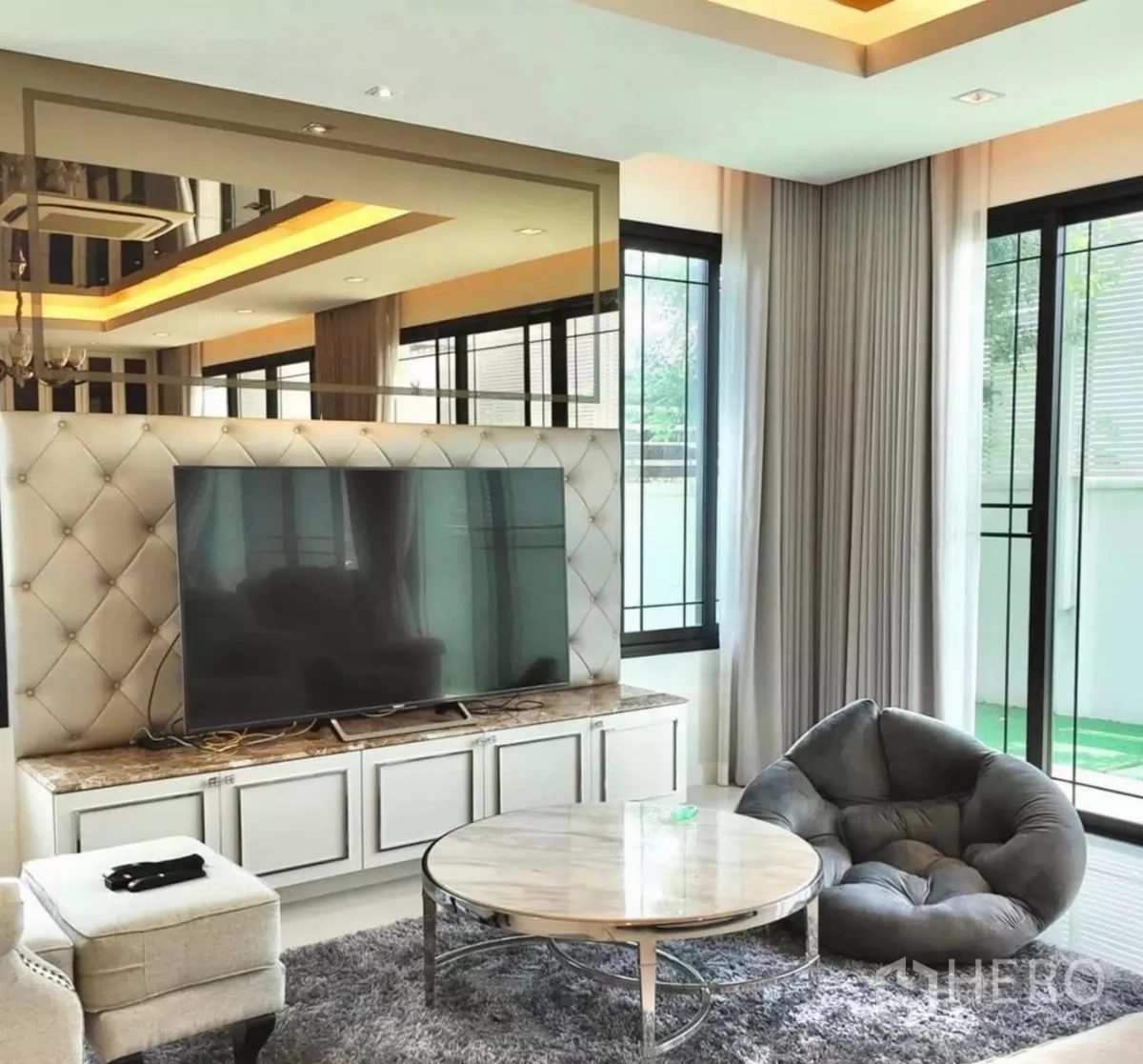 独立式住宅 出租在Bang Bon, Bangkok - 温馨影音角，电视柜、软椅与大窗。