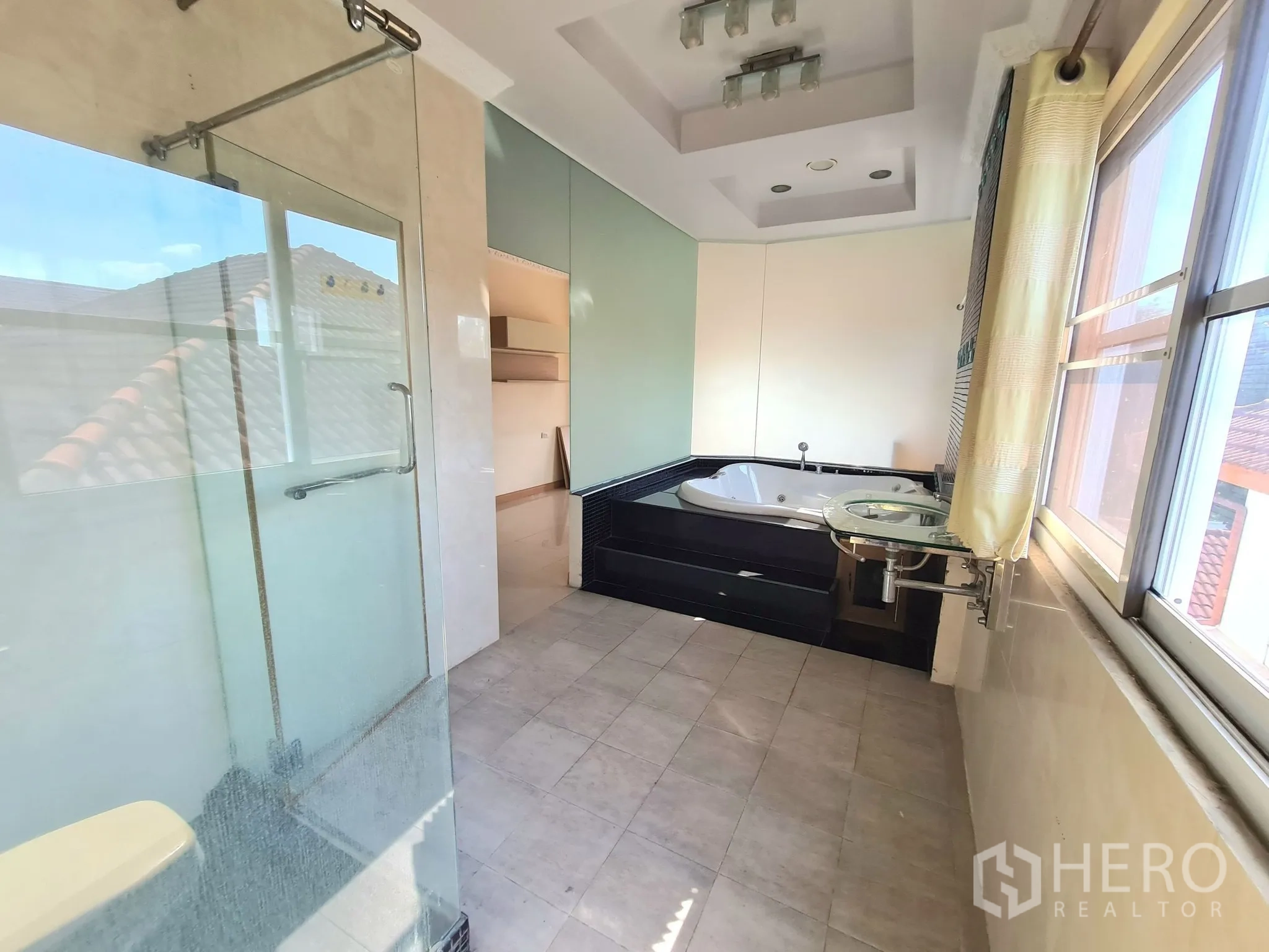 Detached House for sale in Chatuchak, Bangkok - Modern bathroom with glass shower, corner jacuzzi tub and vanity.