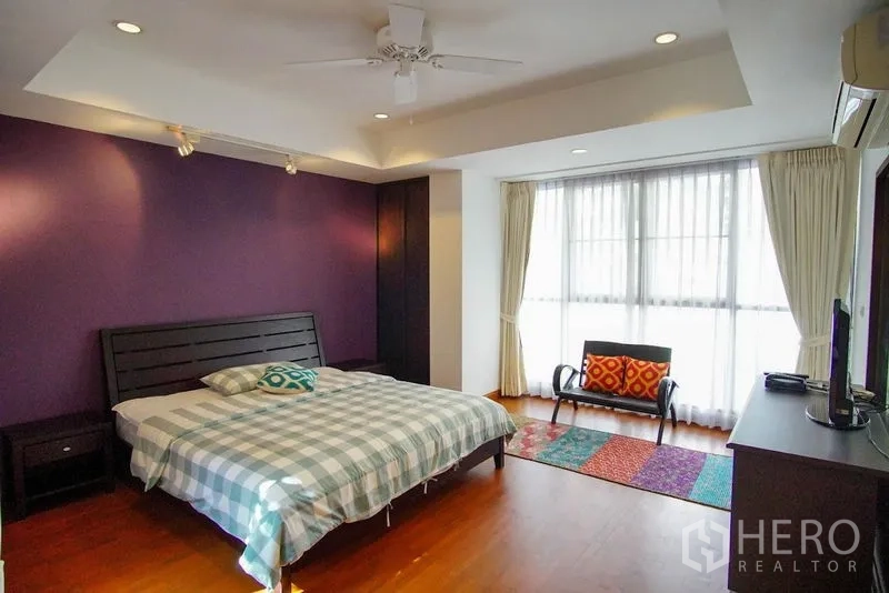 ทาวน์เฮาส์ ให้เช่าในWatthana, Bangkok - ห้องนอนกว้าง ผนังสีม่วง เตียงคิง และหน้าต่างบานใหญ่