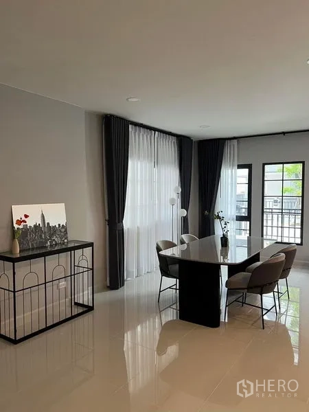 独立式住宅 出租在Bang Phli, Samut Prakan - 餐区四人餐桌，落地窗旁并可通往露台。