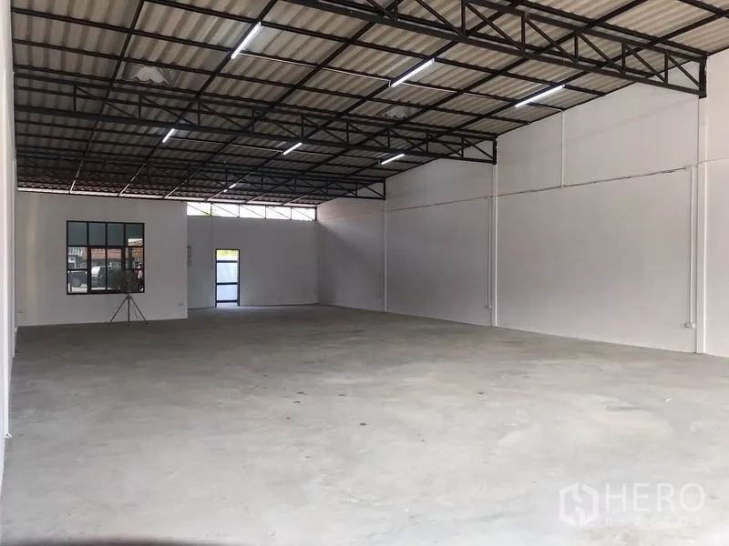 Warehouse for rent in Lam Luk Ka, Pathum Thani - Open warehouse bay with white walls, metal roof structure and wide clear-span concrete floor.