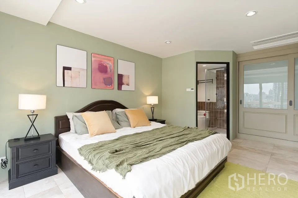 公寓 for rent in Watthana, Bangkok - 主卧配特大床、床头灯与套内卫浴。
