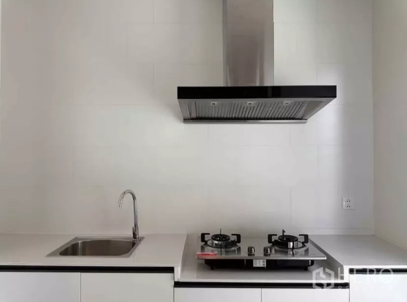 Detached House for rent in Samut Prakan - Thai kitchen with twin-burner gas hob and stainless-steel range hood.
