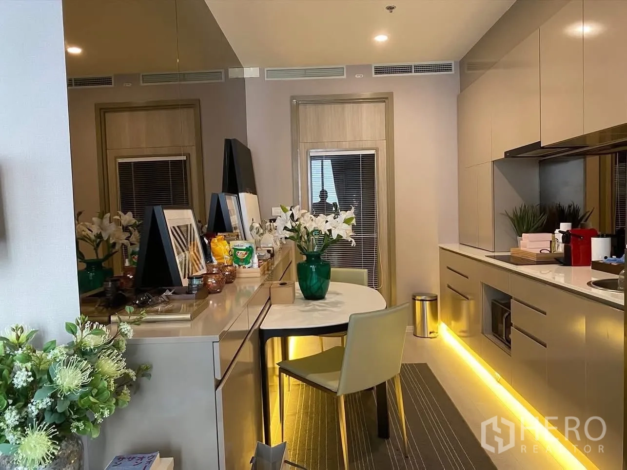 公寓 for rent in Pathum Wan, Bangkok - 当代风厨房与用餐区，整墙橱柜与柜下LED灯带。