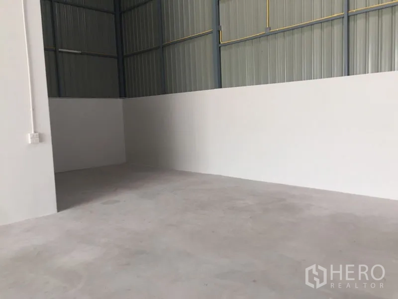 货栈 出售在Khlong Luang, Pathum Thani - 仓库角落，半高白墙与水泥地面。