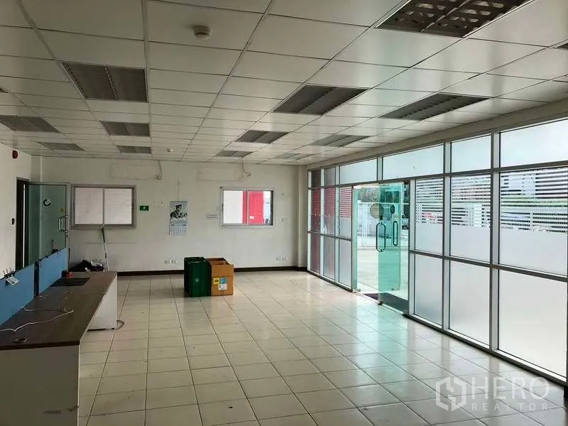 Factory for rent in Bang Sao Thong, Samut Prakan - Open-plan office with glass sliding entrance and long workstation counters.