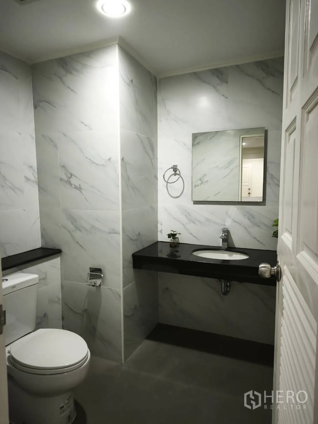 คอนโด for rent in Watthana, Bangkok - ห้องน้ำกรุกระเบื้องลายหินอ่อน เคาน์เตอร์ท็อปสีดำ พร้อมโถสุขภัณฑ์และกระจกเงา