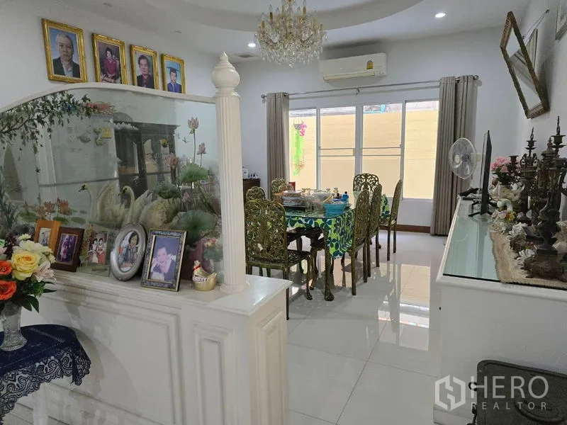 Land for sale - Open dining area with chandelier, decorative display cabinets, and wide windows.