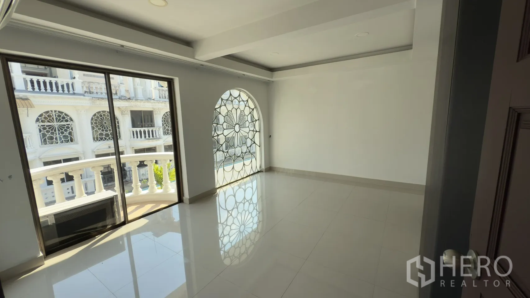 联排别墅 for rent in Watthana, Bangkok - 卧室设拱形花纹窗与推拉门，连接弧形阳台。