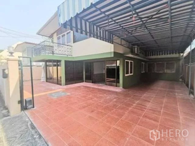 带办公室的家 出租在Wang Thonglang, Bangkok - 宽敞前庭，红色地砖、条纹金属雨棚、阳台与推拉玻璃门