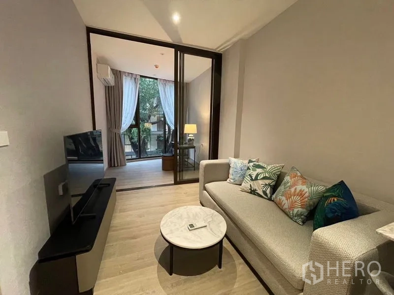 Condominium for rent in Khlong Toei, Bangkok - Cozy lounge opening via sliding glass to bedroom or study with large windows