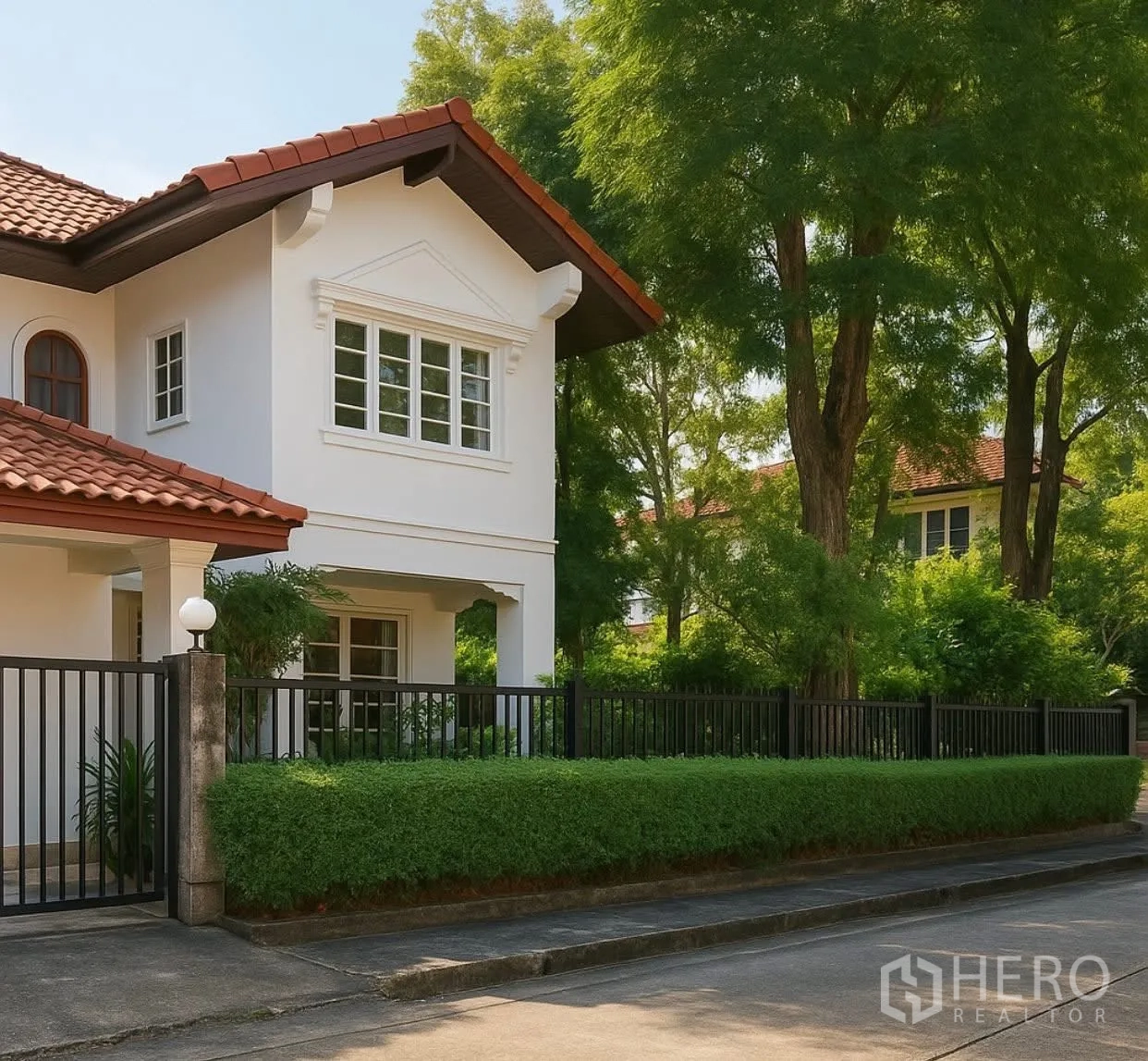 Detached House for rent in Saphan Sung, Bangkok - Front facade of white two-storey house with fence and hedge.