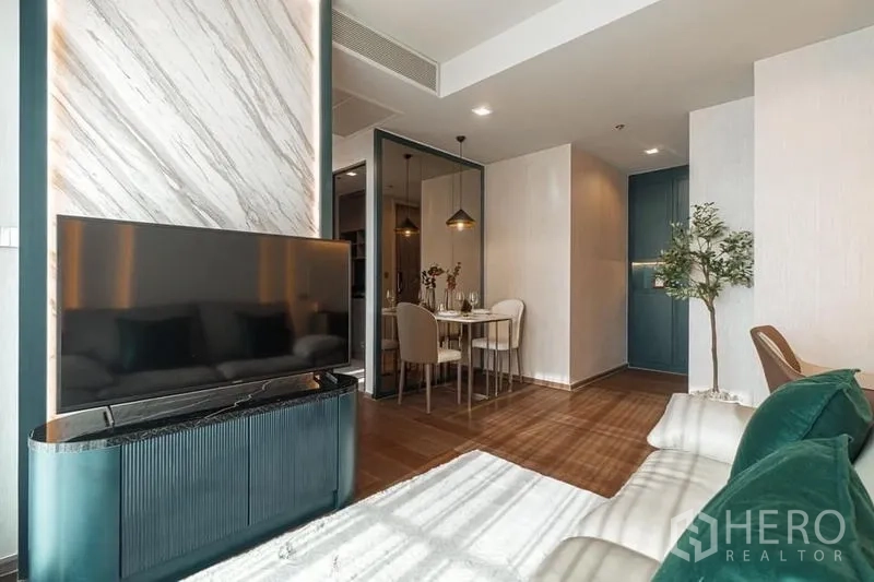 Condominium for rent in Khlong Toei, Bangkok - Dining corner with mirrored wall and two pendant lamps over a white table.