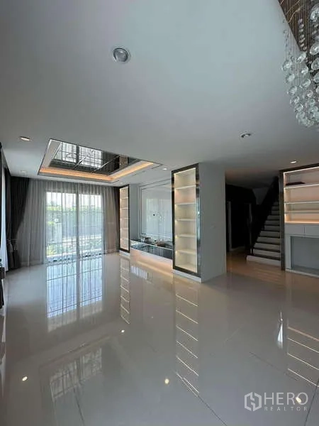 独立式住宅 出售在Prawet, Bangkok - 开放式起居区，亮面地砖、内置陈列柜与楼梯。
