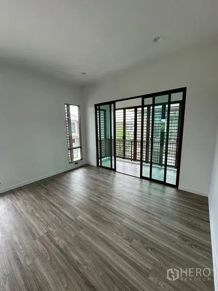 独立式住宅 出租在Bang Kapi, Bangkok - 二层房间通向带木格栅的阳台，推拉玻璃门相连。