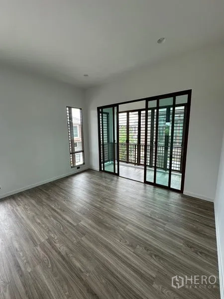 独立式住宅 出租在Bang Kapi, Bangkok - 二层房间通向带木格栅的阳台，推拉玻璃门相连。