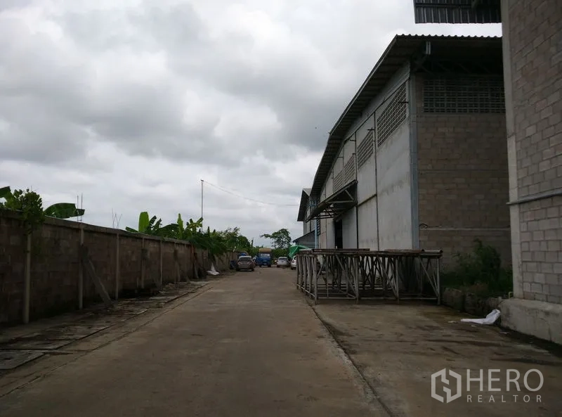 โรงงาน ให้เช่าหรือขายในKrathum Baen, Samut Sakhon - ถนนภายในกว้างข้างอาคารโรงงานขนาดใหญ่ พร้อมกันสาดจุดขนถ่ายและพื้นที่จอดรถ ในอำเภอกระทุ่มแบน สมุทรสาคร
