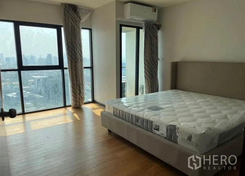 Condominium for rent - Bright bedroom with floor-to-ceiling windows, balcony door and skyline views.