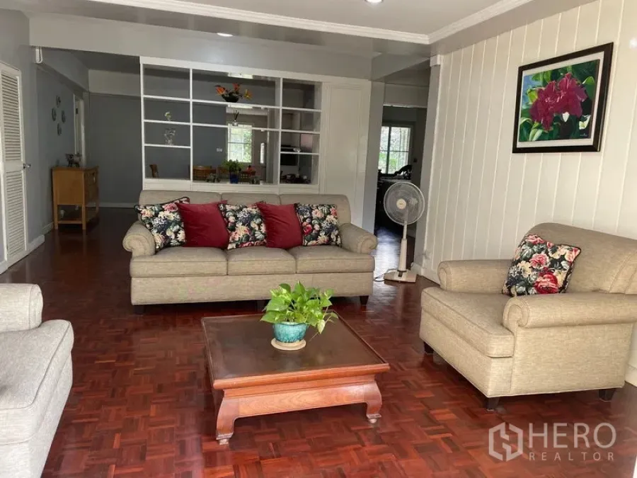 Condominium for rent in Watthana, Bangkok - Open-plan lounge with sofa set, coffee table and white display shelving.