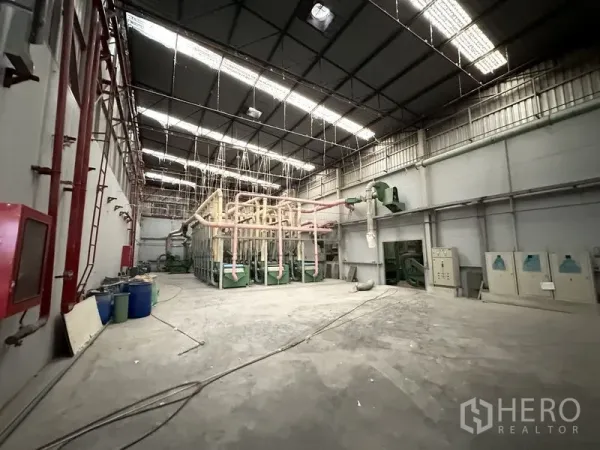 Factory for rent in Bang Bua Thong, Nonthaburi - Machinery zone with ventilation piping and control panels under skylights.