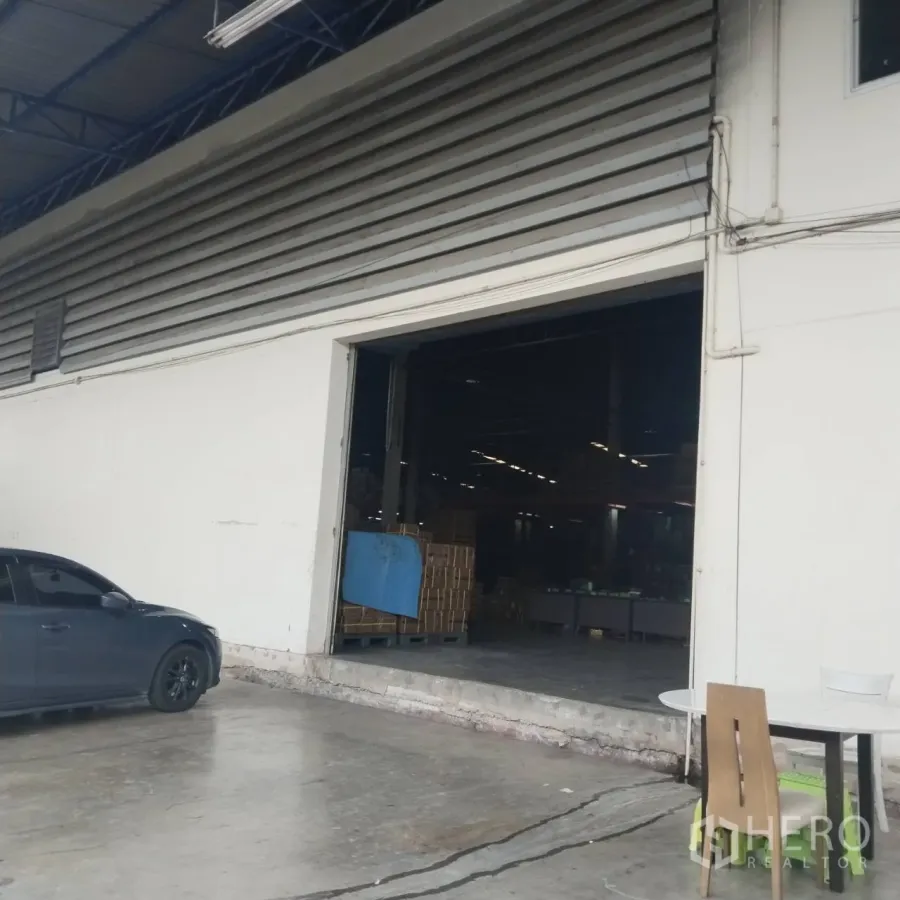Warehouse for rent in Bang Khun Thian, Bangkok - Covered loading bay with wide warehouse entrance and concrete apron.