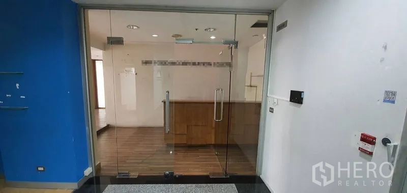 สำนักงาน ให้เช่าในWatthana, Bangkok - ประตูกระจกบานคู่ทางเข้า สู่โถงต้อนรับพร้อมเคาน์เตอร์ไม้และพื้นไม้.