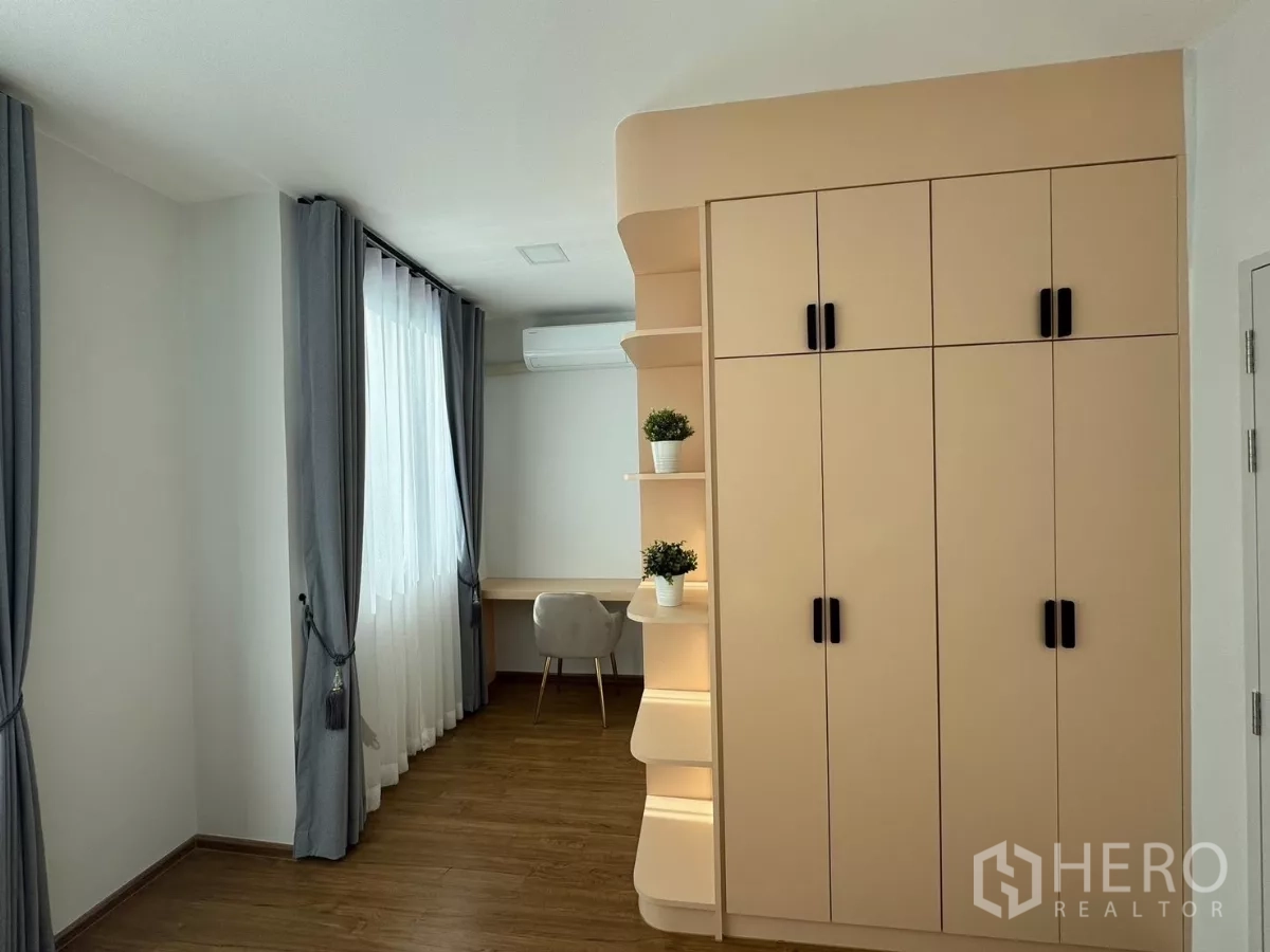 Townhouse for rent in Bang Phli, Samut Prakan - Spacious bedroom with built-in wardrobe, study desk, and long drapes
