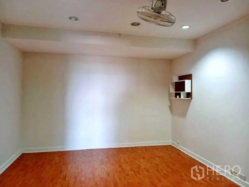 Condominium for rent in Khlong Toei, Bangkok - Empty flex room with wood floors, recessed lights and a small wall shelf.