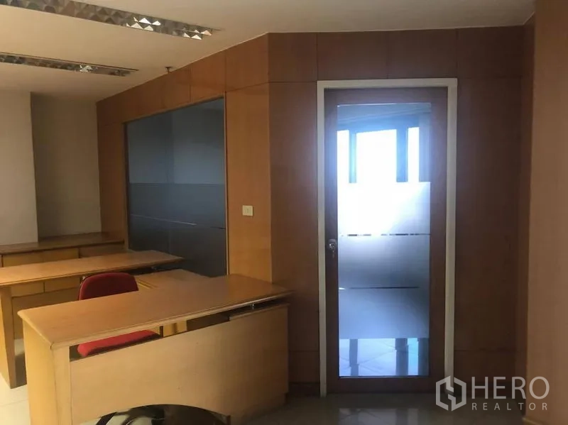 Office Space for rent in Sathon, Bangkok - Workstations facing a frosted glass door leading to another room, with built-in cabinetry.