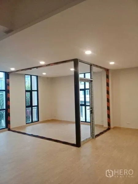 带办公室的家 出租在Bang Kapi, Bangkok - 明亮的室内办公区，设玻璃墙会议室与浅木地板。