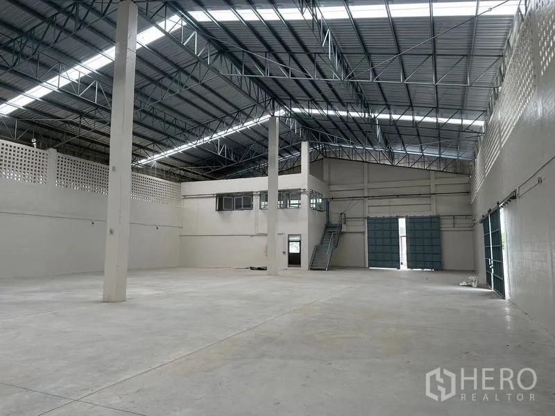 工厂 出租在Lam Luk Ka, Pathum Thani - 宽大厂房地面，夹层办公室、楼梯与高卷门。