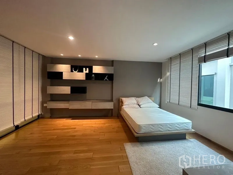 联排别墅 出售在Saphan Sung, Bangkok - 明亮卧室，极简床铺、墙面搁架与大窗户。