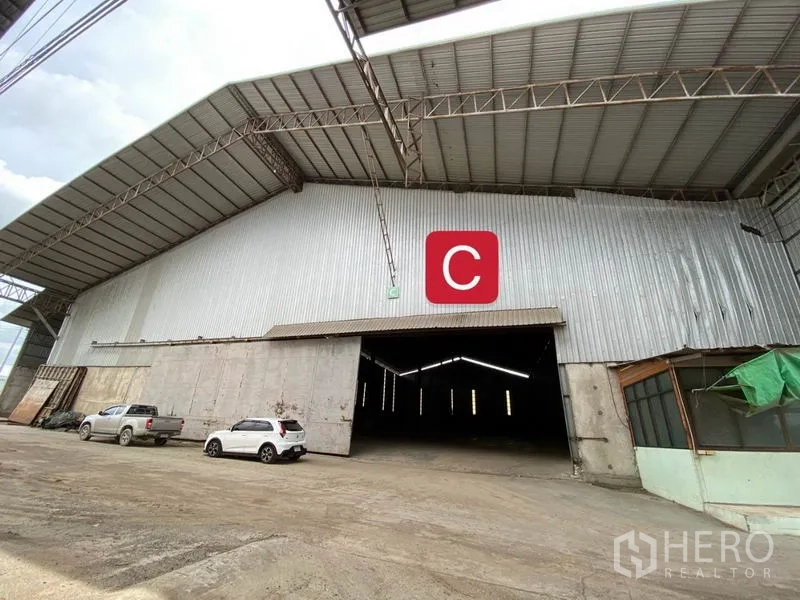 Factory for rent in Chachoengsao - Exterior of a large steel-clad factory with a high gable roof, wide loading entrance and parking apron.