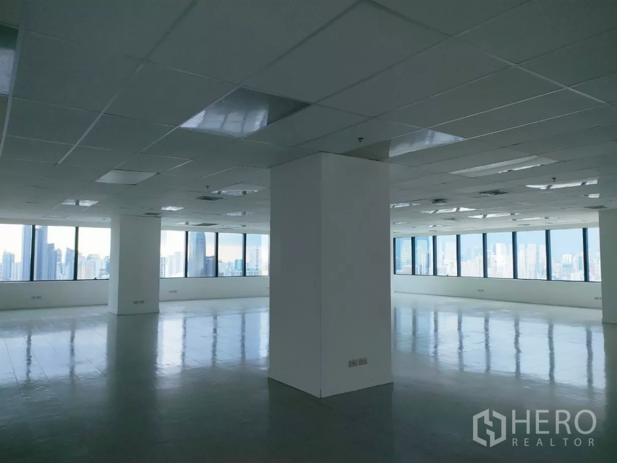 Office Space for rent in Huai Khwang, Bangkok - Spacious columned office area with grid ceiling, AC vents, and city views.