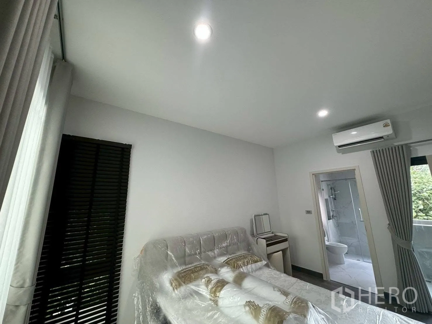 บ้านแฝด for rent in Suan Luang, Bangkok - ห้องนอนสว่างพร้อมเตียง เครื่องปรับอากาศ และห้องน้ำติดกัน.