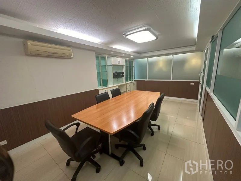 Office Space for sale - Meeting room with six chairs, wood table and glass display cabinets.