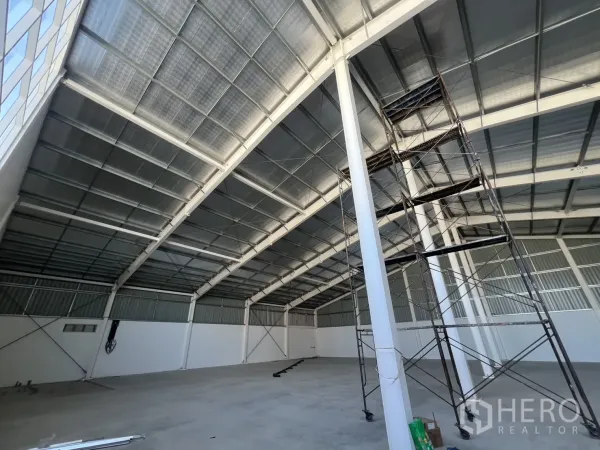 คลังสินค้า ให้เช่าในMin Buri, Bangkok - เพดานสูงเผยโครงหลังคาเหล็กและนั่งร้านสำหรับงานบำรุงรักษา