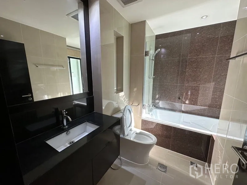 คอนโด ให้เช่าในSathon, Bangkok - ห้องน้ำพร้อมอ่างอาบน้ำกั้นกระจก อ่างล้างหน้าเคาน์เตอร์สีดำและกระจกบานใหญ่