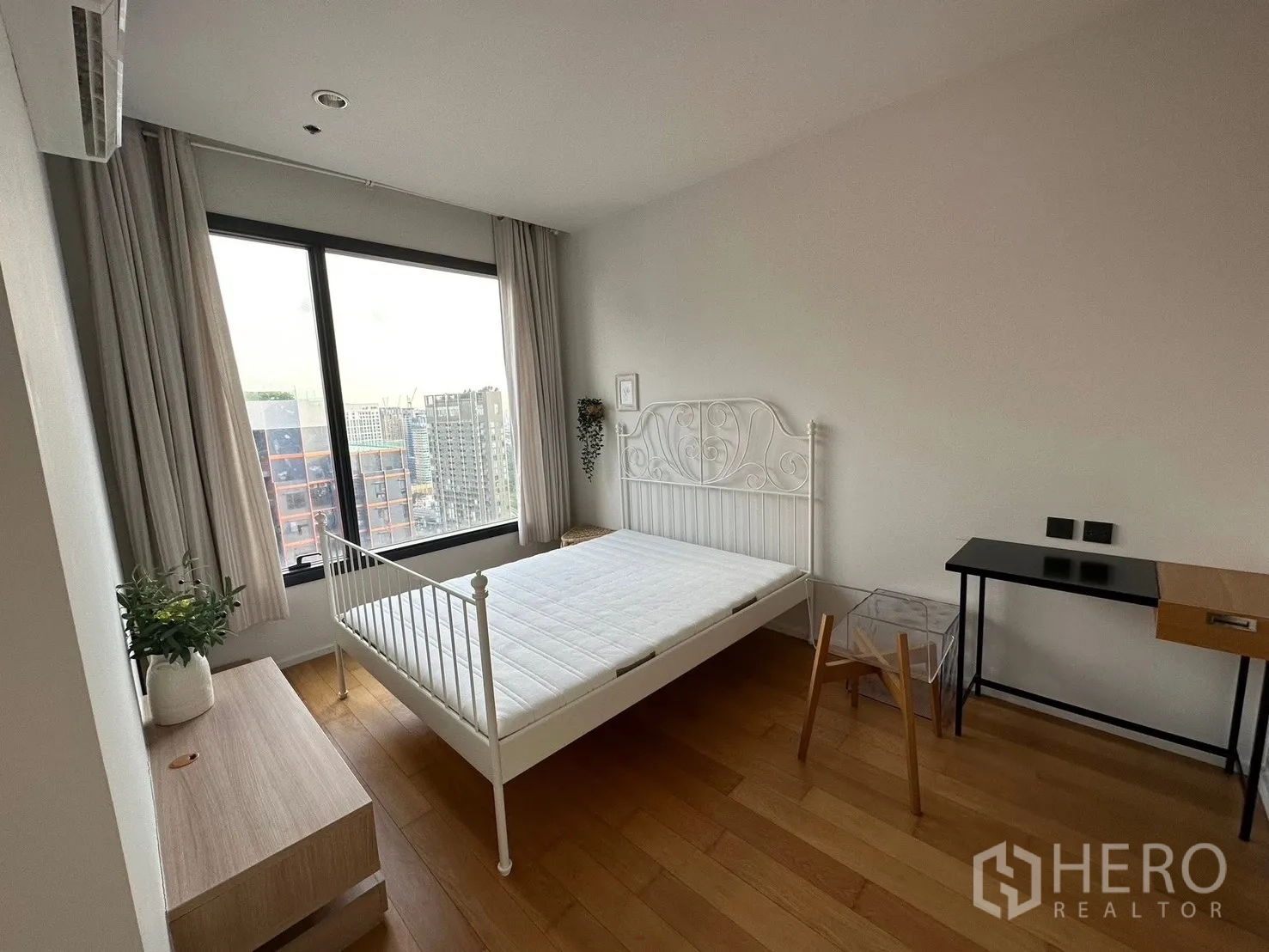 Condominium for rent or sale in Chatuchak, Bangkok - Bedroom with large window, city view, bedframe, and work desk.