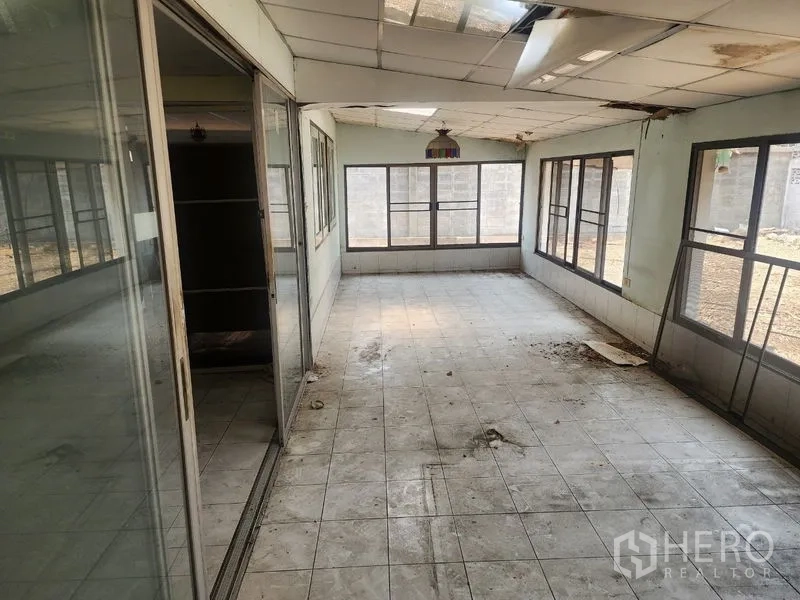 Detached House for rent in Watthana, Bangkok - Enclosed sunroom with tiled floor and sliding glass doors, showing renovation needs.