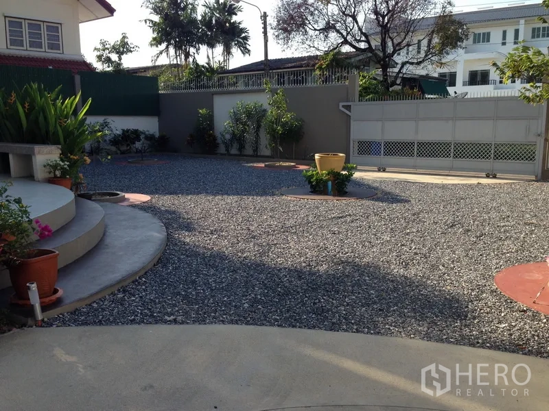 Detached House for sale in Phra Khanong, Bangkok - Large gated gravel courtyard with planters and curved steps, offering ample parking space.
