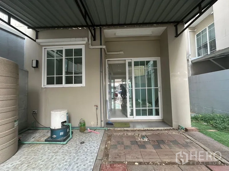 Home Office for rent in Bang Na, Bangkok - Covered rear patio with sliding glass door, water pump and storage tank.