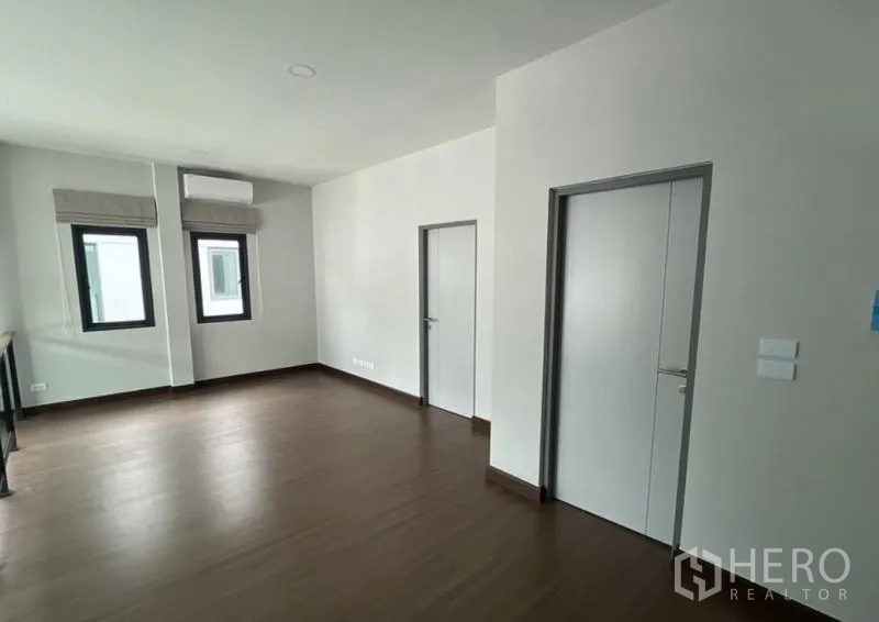 Detached House for rent in Bang Phli, Samut Prakan - Upper landing or multipurpose room with two interior doors and wood-look flooring.