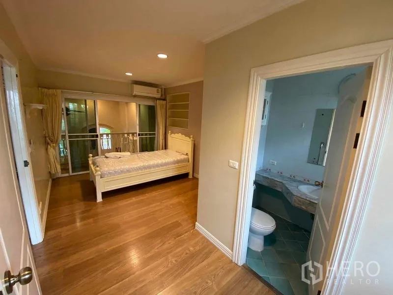 Townhouse for rent or sale in Mueang Samut Prakan, Samut Prakan - Bedroom with ensuite bathroom and sliding doors to an internal balcony.