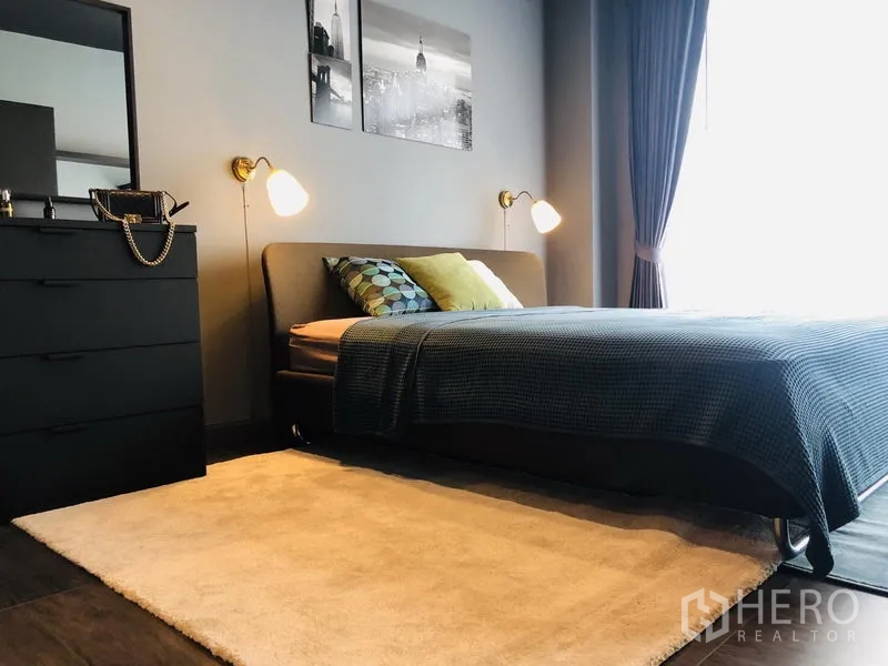 Townhouse for rent in Bang Kapi, Bangkok - Bright master bedroom with double bed, bedside lamps, dresser and large window.